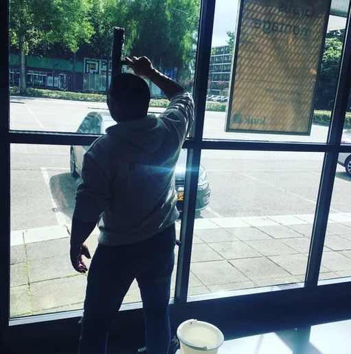 Olympus-medewerker reinigt het glas van een entree met een inwasser